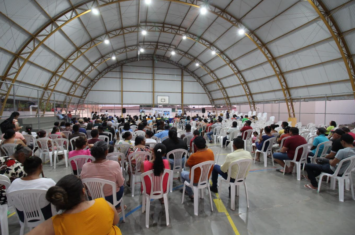 Quadra coberta com cadeiras e pessoas sentadas