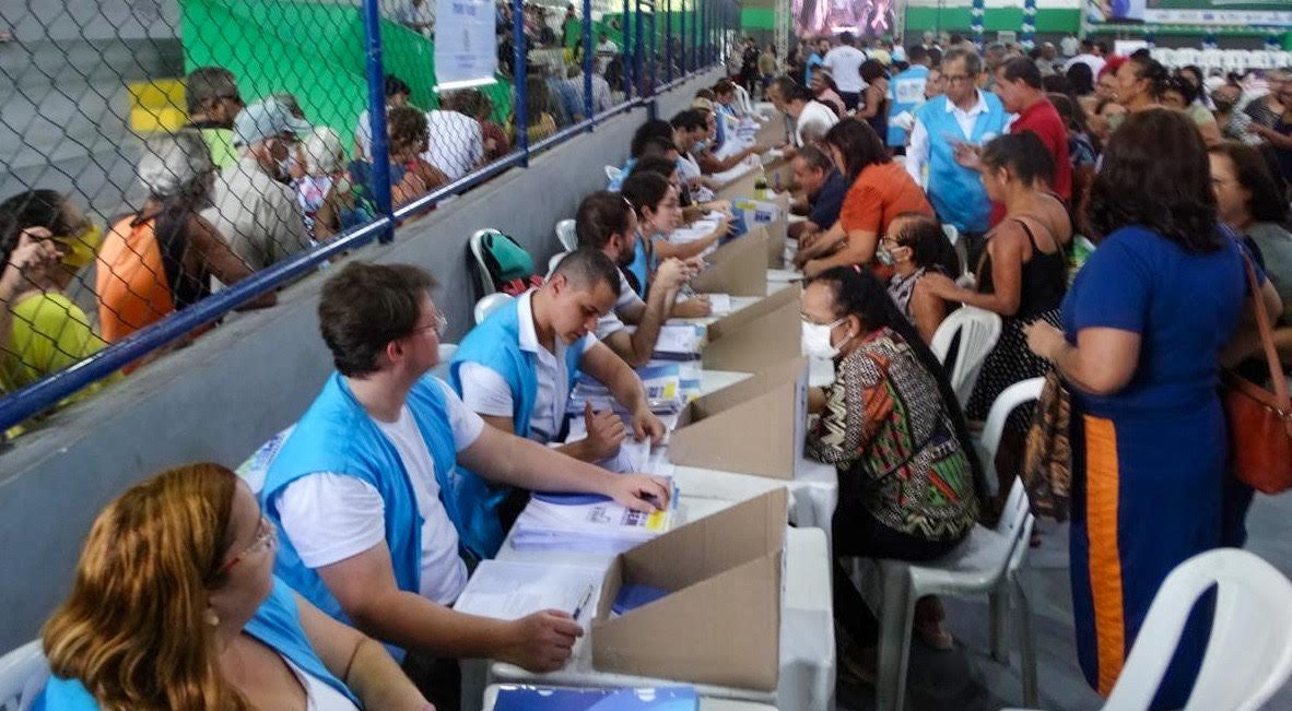 Pessoas em pé e sentadas sendo atendidas